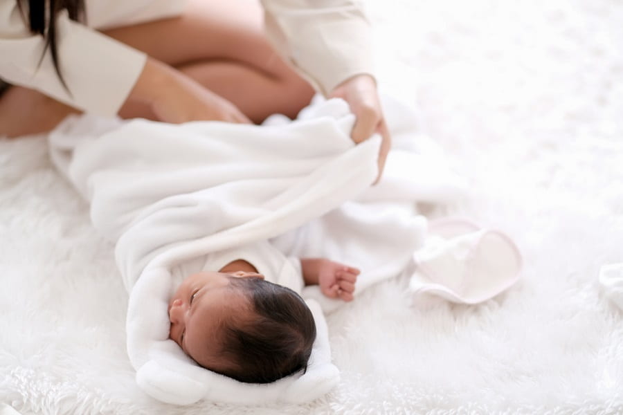 Newborn baby was swaddling with white cloth by her mother - Roll Up Baby